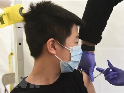 Nhân viên y tế tiêm vaccine phòng COVID-19 cho trẻ em. (Ảnh: AFP/TTXVN).