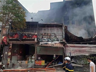 Hiện trường vụ cháy tại địa chỉ ở số 63 Nguyễn Hoàng lan ra nhiều nhà xung quanh. (Ảnh: TTXVN phát).