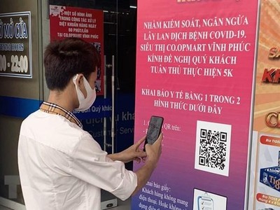 Người dân thực hiện quét mã QR khai báo y tế. (Ảnh: Hoàng Hùng/TTXVN)