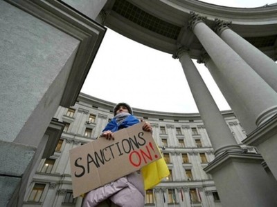 Một người biểu tình ủng hộ các lệnh trừng phạt chống lại Nga đứng bên ngoài Bộ Ngoại giao Ukraine ở Kiev ngày 21/2. Ảnh: AFP.