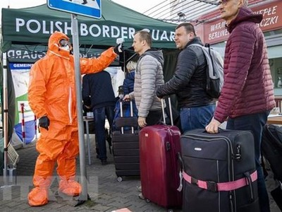 Nhân viên y tế kiểm tra thân nhiệt hành khách đi qua cửa khẩu biên giới Đức-Ba Lan. (Nguồn: AFP/TTXVN).