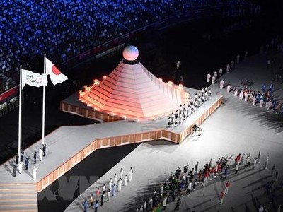Quốc kỳ Nhật Bản (phải) và cờ Olympic tại lễ khai mạc Olympic Tokyo 2020 ở Tokyo, Nhật Bản, ngày 23/7/2021. (Ảnh: AFP/ TTXVN).