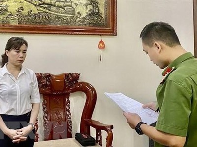 Cán bộ Phòng Cảnh sát điều tra tội phạm về tham nhũng, kinh tế, buôn lậu Công an tỉnh Cao Bằng tống đạt quyết định khởi tố bị can, lệnh bắt bị can để tạm giam đối với bà Hoàng Thị Xuyến, Giám đốc Ban quản lý dự án đầu tư và xây dựng huyện Bảo Lạc. (Ảnh: TTXVN phát).