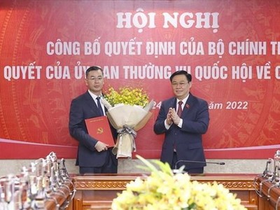 Chủ tịch Quốc hội Vương Đình Huệ trao Quyết định của Bộ Chính trị và tặng hoa ông Ngô Văn Tuấn. (Ảnh: Doãn Tấn/TTXVN).