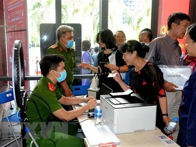 Công an làm căn cước công dân gắn chíp cho người dân tại điểm dịch vụ công trực tuyến. (Ảnh: Thành Chung/TTXVN)