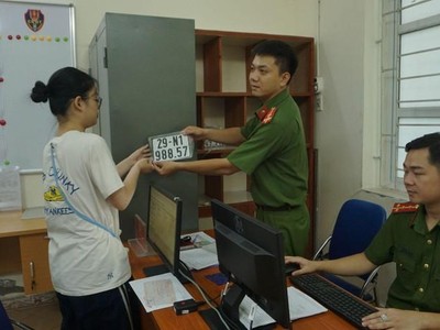 Lực lượng công an cấp biển số xe máy cho người dân đến đăng ký, bấm biển (Ảnh: Hoàng Hiệp).