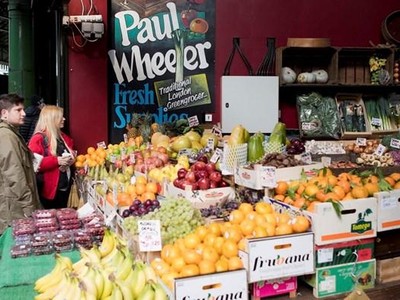Khách hàng chọn mua hoa quả và rau tại một chợ ở London, Anh. (Ảnh: AFP/TTXVN).