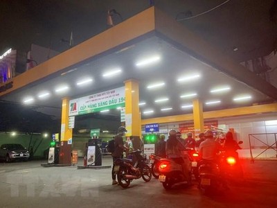 Người dân mua xăng tại Cửa hàng xăng dầu trên đường Hoàng Văn Thụ (quận Phú Nhuận, Thành phố Hồ Chí Minh), tối ngày 12/10. (Ảnh: Hồng Đạt/TTXVN)