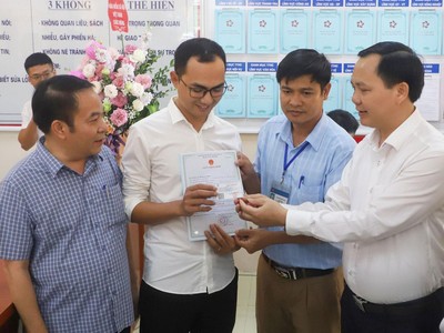 Phó tổng giám đốc BHXH Việt Nam Chu Mạnh Sinh trao thẻ BHYT của bé gái cho anh Đinh Tiến Hoàng.