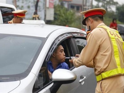 Cảnh sát giao thông huyện Sơn Dương kiểm tra nồng độ cồn của lái xe. (Ảnh: Nam Sương/TTXVN)