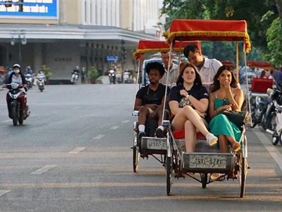 Du khách trải nghiệm du lịch quanh hồ Hoàn Kiếm bằng xíchlô. (Ảnh: Khánh Hòa/TTXVN)