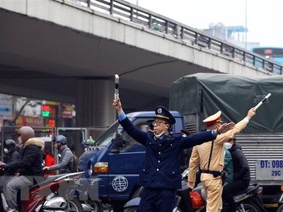 Lực lượng Thanh tra giao thông, cảnh sát giao thông hướng dẫn các phương tiện đi theo đúng tuyến đường. (Ảnh: Huy Hùng/TTXVN)
