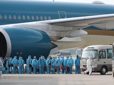 Các công dân xuống máy bay vào xe để về khu cách ly y tế. (Ảnh: Thành Đạt/TTXVN)