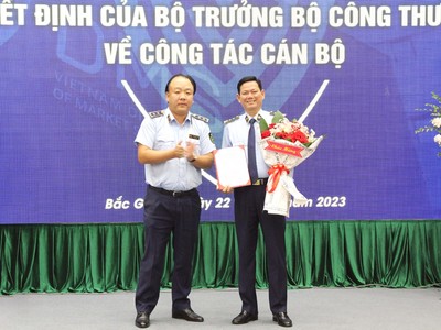 Tổng Cục trưởng Tổng Cục QLTT Trần Hữu Linh trao Quyết định và tặng hoa chúc mừng đồng chí Chu Thanh Hiến.