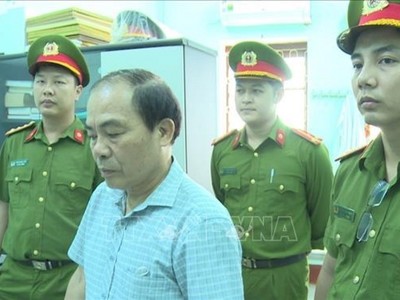 Đại diện Cơ quan công an đọc lệnh khởi tố bị can đối với Đinh Văn Khoa. Ảnh: TTXVN phát