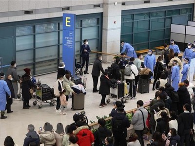 Du khách Trung Quốc được hướng dẫn tới khu vực kiểm dịch COVID-19 tại sân bay quốc tế Incheon, phía Tây Seoul (Hàn Quốc) ngày 2/1/2023. (Ảnh: AFP/TTXVN).
