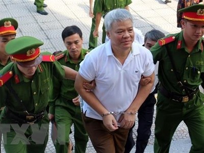 Lực lượng chức năng dẫn giải bị cáo Nguyễn Văn Khuê vào phòng xét xử. (Ảnh: Vũ Hà/TTXVN)