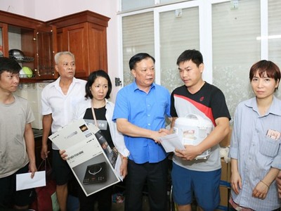 Bí thư Thành ủy Đinh Tiến Dũng động viên, trao hỗ trợ cho các gia đình trong vụ cháy chung cư mini tại quận Thanh Xuân. (Ảnh: Xuân Quảng/Vietnam+).