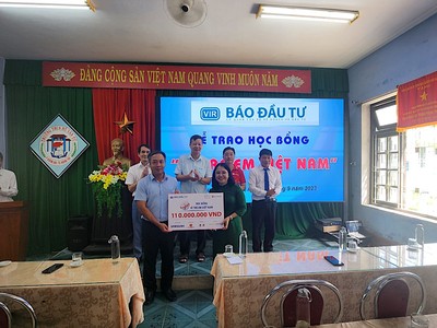 Ông Lê Trọng Minh, Tổng Biên tập Báo Đầu tư trao biểu trưng học bổng cho đại diện nhà trường.