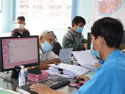 Cán bộ UBND phường Hiệp Bình Chánh, thành phố Thủ Đức, Thành phố Hồ Chí Minh giải quyết hồ sơ cho người dân. (Ảnh: Xuân Tình/TTXVN)