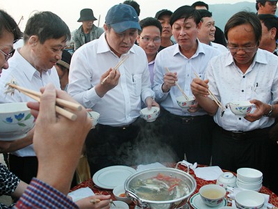 Ông Huỳnh Đức Thơ (người đội mũ) đã trực tiếp chế biến và thưởng thức hải sản của ngư dân ngay tại cảng cá. Ảnh: Đ.X.