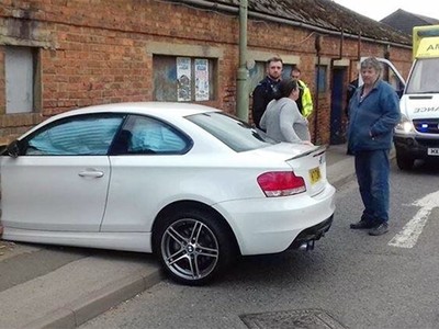 Chiếc BMW serie 1 màu trắng nằm gọn tronglỗ thủng do chính mình tạo ra. Ảnh:Reddit.