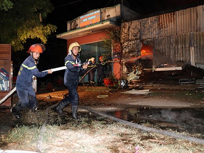 Lửa bùng lên trong nhà kho chứa hàngđiện tử, lan sang ba căn nhà liền kề. Ảnh:Thanh Châu.