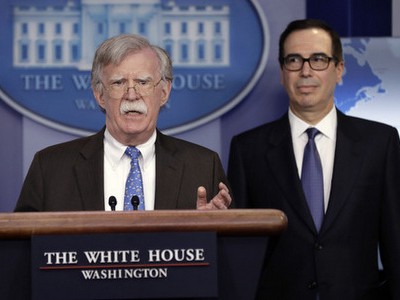 Cố vấn Bolton (trái) và Bộ trưởng Mnuchin công bố lệnh cấm vận. Ảnh:AFP.