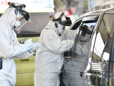 Nhân viên y tế kiểm tra thân nhiệt lái xe nhằm ngăn ngừa sự lây lan của virus SARS-CoV-2 tại Goyang, phía Bắc Seoul ngày 29/2/2020. (Ảnh: AFP/TTXVN)