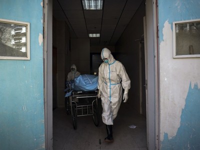 Nhân viên y tế di chuyển một người chết do Covid-19 tại một bệnh viện ở Vũ Hán. Ảnh: AP.