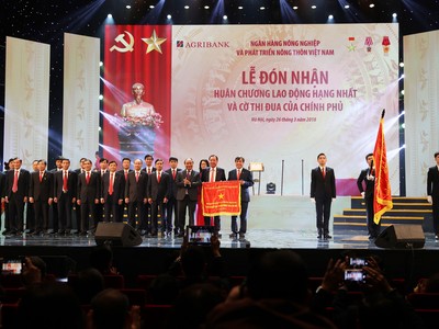 Thủ tướng Chính phủ Nguyễn Xuân Phúc gắn Huân chương Lao động hạng Nhất lên Lá cờ truyền thống của Agribank.