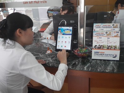 Cán bộ nhân viên LienVietPostBank đang thực hành sử dụng máy tính bảng để giới thiệu cho khách hàng