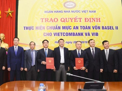 Thống đốc NHNN Việt Nam Lê Minh Hưng (đứng giữa) cùng Phó thống đốc NHNN Đoàn Thái Sơn (thứ 3 từ trái sang) trao quyết định cho Vietcombank và VIB