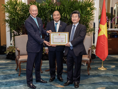 Ông Wee Ee Cheong, Phó chủ tịch kiêm Tổng giám đốc tập đoàn UOB, nhận bằng khen từ ông Đỗ Nhất Hoàng, Cục trưởng Cục Đầu tư nước ngoài trước sự chứng kiến của Chủ tịch nước Nguyễn Xuân Phúc