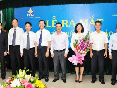 Thứ trưởng Bộ Tài chính Trần Xuân Hà tặng hoa và chụp ảnh lưu niệm cùng các thành viên Hội đồng quản lý Quỹ Bảo vệ người được bảo hiểm 