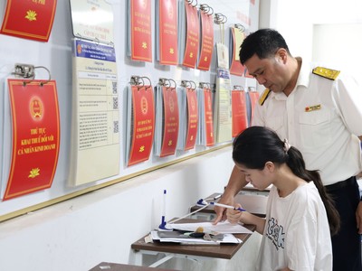 Công chức thuế hướng dẫn người dân làm thủ tục kê khai thuế. Ảnh: Dũng Minh