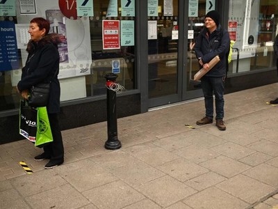 Người mua hàng tại Anh thực hiện giãn cách xã hội. Ảnh: AFP