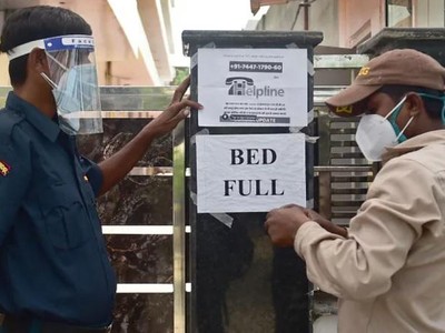 Nhân viên an ninh tại một bệnh viện tư nhân ở thành phố Allahabad, Ấn Độ thông báo hôm 22/4 tới người dân rằng bệnh viện này đã hết giường. Ảnh: AFP