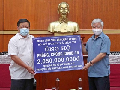 Đại diện Bộ Kế hoạch và Đầu tư, Bộ trưởng Nguyễn Chí Dũng (bìa trái) trao 2,05 tỷ đồng đóng góp cho hoạt động phòng chống dịch Covid-19 cho Chủ tịch Ủy ban Trung ương MTTQ Việt Nam Đỗ Văn Chiến (Ảnh: Đức Trung)