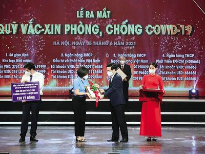 Ông Võ Văn Thưởng trao hoa và giấy chứng nhận cho các đơn vị, cá nhân quyên góp thành lập Quỹ Vắc-xin phòng chống Covid-19. Ảnh: Q.V