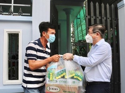 Chủ tịch UBND TP.HCM Nguyễn Thành Phong (bên phải) tặng quà cho người dân nghèo ở huyện Nhà Bè