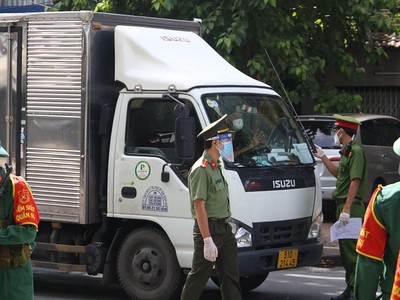 Lực lượng chức năng tại chốt kiểm soát kiểm tra giấy tờ lưu thông của tài xế vận chuyển lương thực, thực phẩm. (ảnh: Lê Toàn)