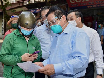 Thủ tướng kiểm tra giấy đi đường của người dân khi đi kiểm tra đột xuất công tác phòng chống dịch tại phường Thanh Xuân Trung ngày 31/8 (Ảnh: Nhật Bắc)