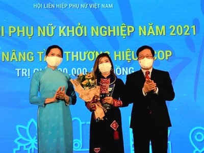Phó Thủ tướng Thường trực Phạm Bình Minh và Chủ tịch Hội Liên hiệp Phụ nữ Việt Nam Hà Thị Nga trao Giải "Nâng tầm thương hiệu OCOP" cho tác giả Vi Thị Lụa với dự án "Trà diếp cá Lụa Vy"