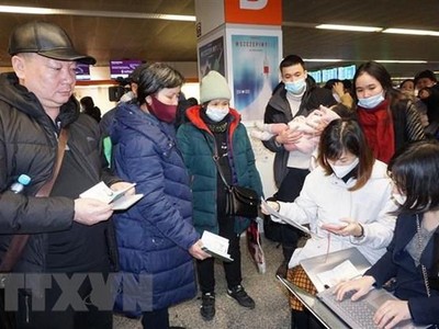 Cán bộ Đại sứ quán Việt Nam tại Ba Lan hỗ trợ thủ tục lên máy bay cho kiều bào sơ tán từ Ukraine. (Ảnh: Hồng Kỳ/TTXVN) 