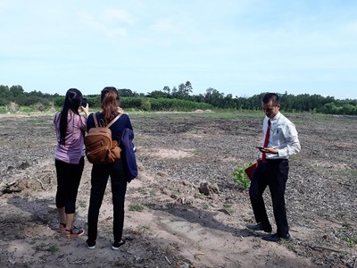 Môi giới dẫn nhà đầu tư đi xem đất. Ảnh: Việt Dũng