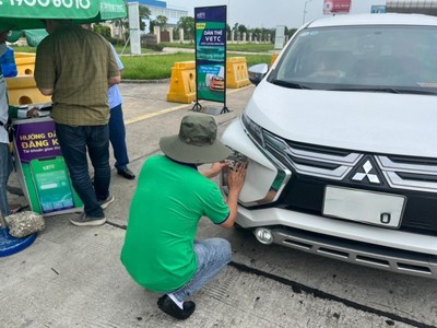 Nhân viên VETC đang dán thẻ thu phí tự động ETC cho khách trên cao tốc.