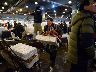 Một tiểu thương với thùng cua ở chợ cá Noryangjin, Seoul. Ảnh: AFP