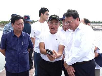 Bộ trưởng Bộ NN&PTNT Lê Minh Hoan (bìa trái) và Chủ tịch UBND tỉnh Trà Vinh Lê Văn Hẳn (bìa phải) tham quan mô hình nuôi tôm công nghệ cao hiệu quả của Tập đoàn Mỹ Lan - Ảnh Văn Vũ