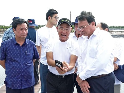 Bộ trưởng Bộ Nông nghiệp và Phát triển nông thôn Lê Minh Hoan (bìa trái) và Chủ tịch UBND tỉnh Trà Vinh Lê Văn Hẳn (bìa phải) tham quan mô hình nuôi tôm công nghệ cao hiệu quả của Tập đoàn Mỹ Lan tại tỉnh Trà Vinh. Ảnh: Văn Vũ